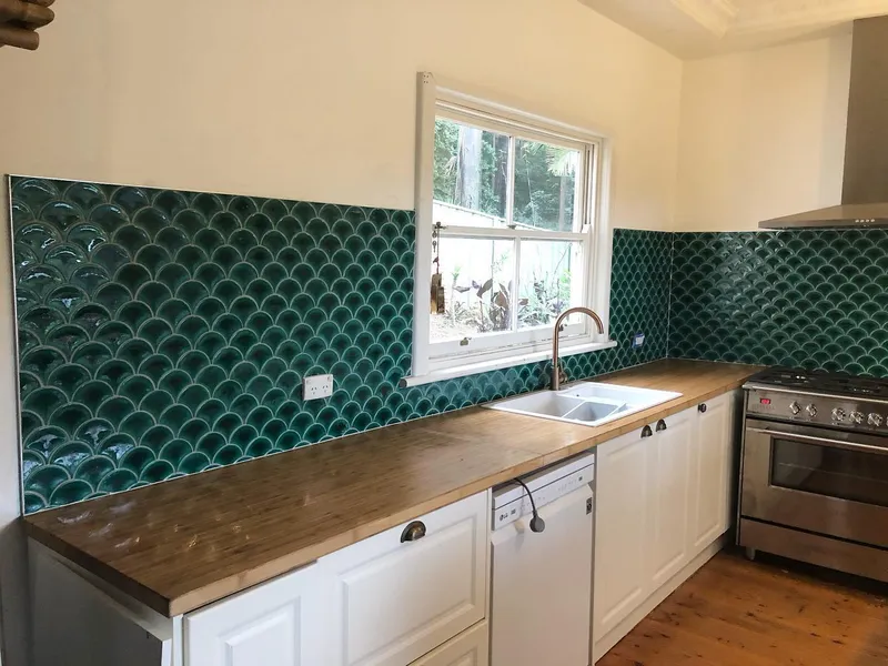 Kitchen splashback with emerald fish-scale tiles