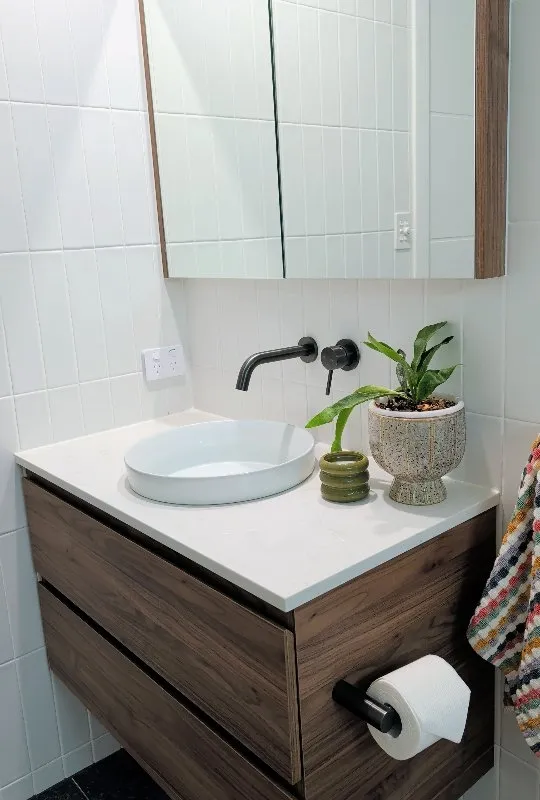 Bathroom with white vertical subway tiles and dark floor tiles