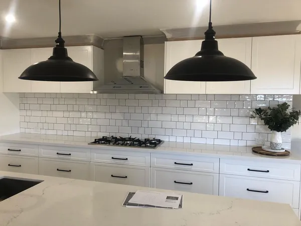 Hamptons-style kitchen with white subway tile splashback and matte black hardware