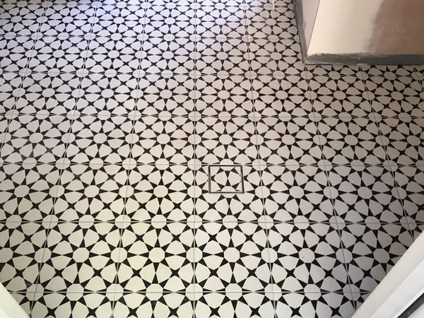 Dramatic black and white geometric encaustic pattern floor tiles