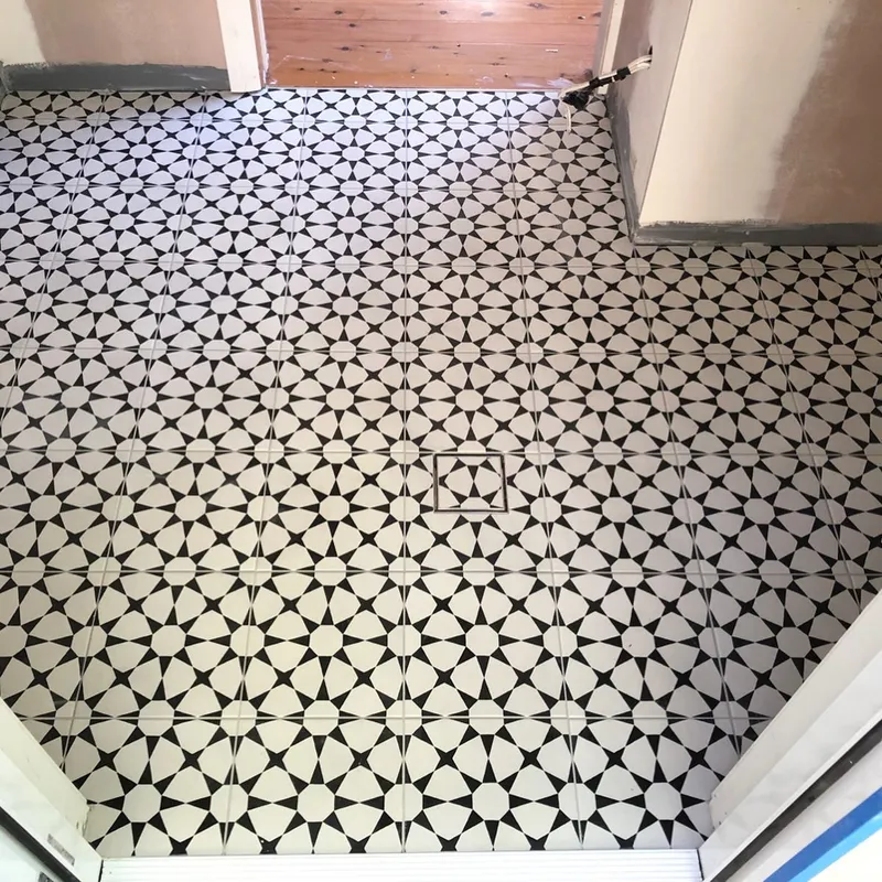 Dramatic black and white geometric encaustic pattern floor tiles