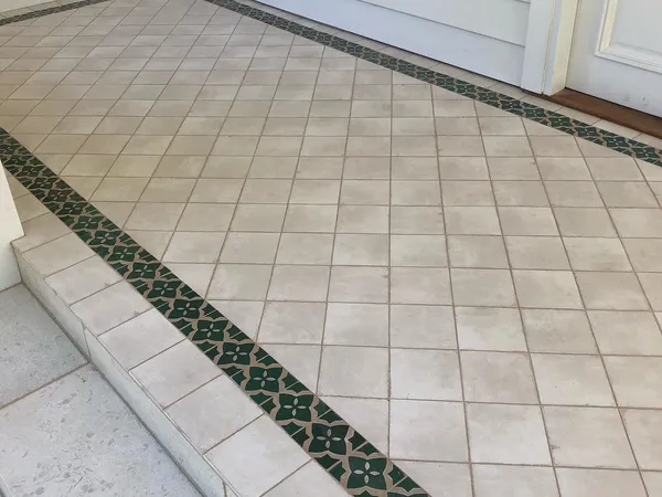 Outdoor alfresco area with cream floor tiles and decorative border strip