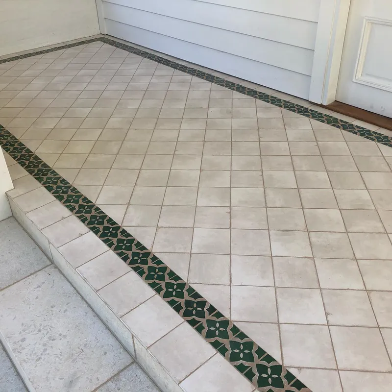 Outdoor alfresco with cream floor tiles and decorative green border strip