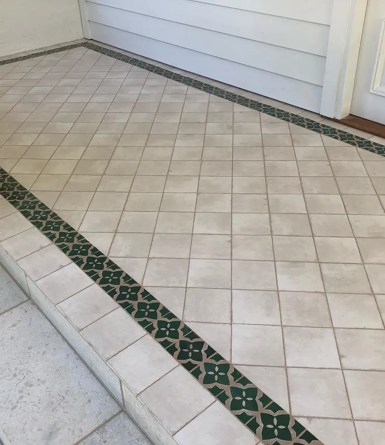 Outdoor verandah with cream floor tiles and decorative green border strip
