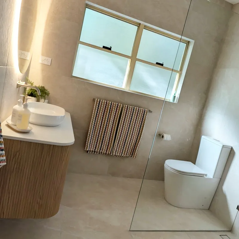 Ensuite renovation with large format stone floor and wall tiles and floating timber vanity